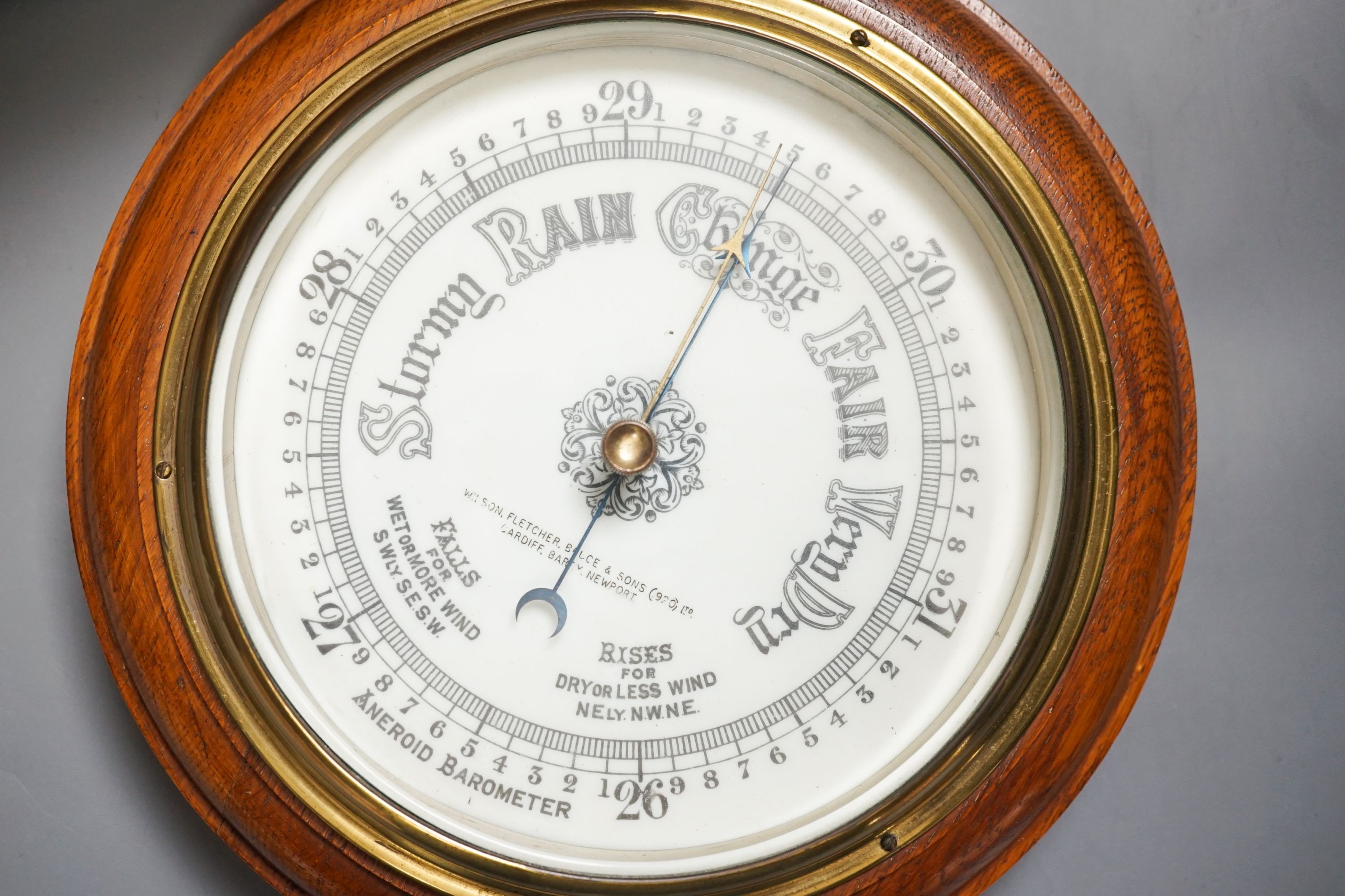 An aneroid barometer in circular polished oak surround and a banded and inlaid two section tea casket, 30.5 x 16.5cm